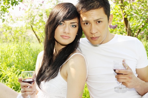 Young couple on a picnic drink wine