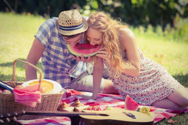 Young couple on a picnic eating watermelon