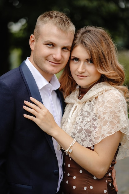 A young couple posing for a photo in a park