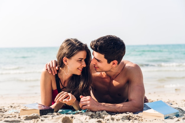 Young couple reading a book on the tropical beach.Couple relaxing on the beach.Summer vacations