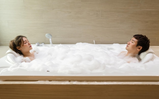 Young couple relaxing in bathtube with eyes closed in bathroom