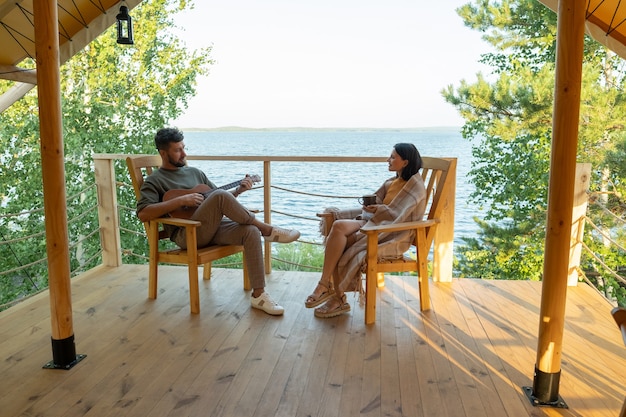 Young couple relaxing on patio of glamping house