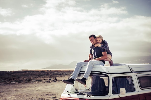 Photo young couple relaxing on van at beach