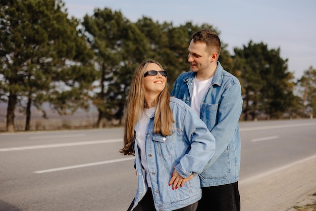 A young couple on the road with a blue denim jacket and sunglasses