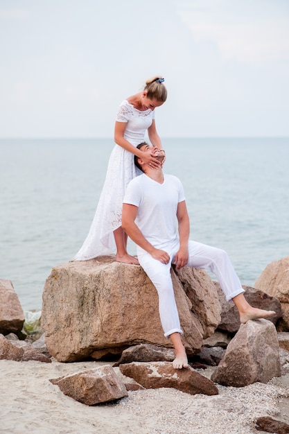 Young couple on the rocks in the sea