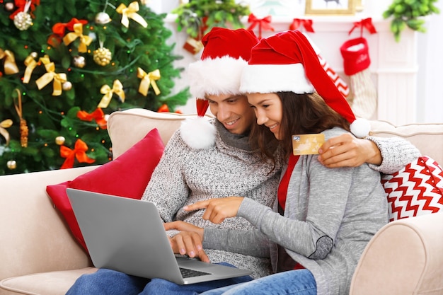 Young couple shopping online with credit card at home for Christmas