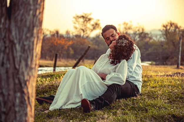 Young couple sitting in the field in love