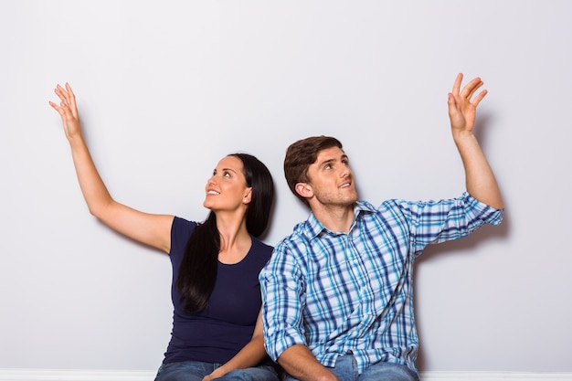 Young couple sitting on floor smiling