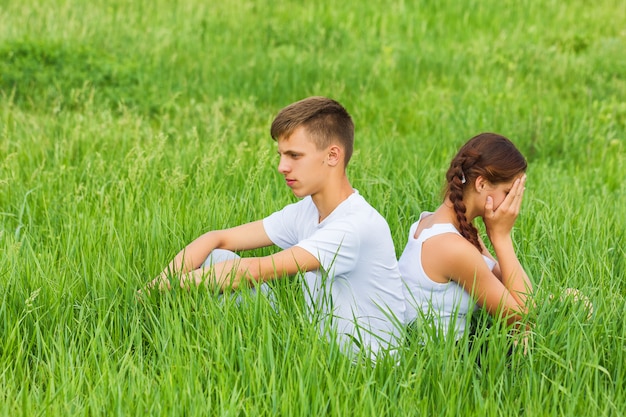 Young couple sitting on a green meadow