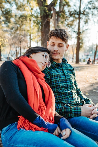 young couple sitting in park enjoying afternoon