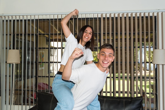 young couple sitting on their couch at home watching a football game