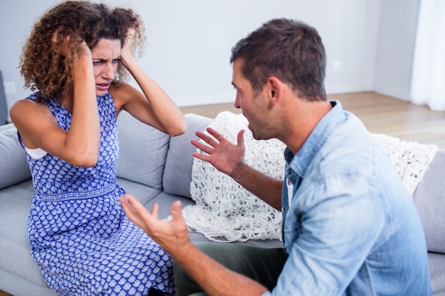 Young couple sitting together and discussing after a fight 