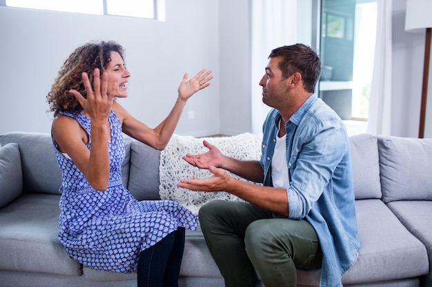 Young couple sitting together and discussing after a fight