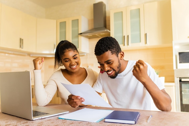 Young couple sitting with laptop and education online at kitchen at home