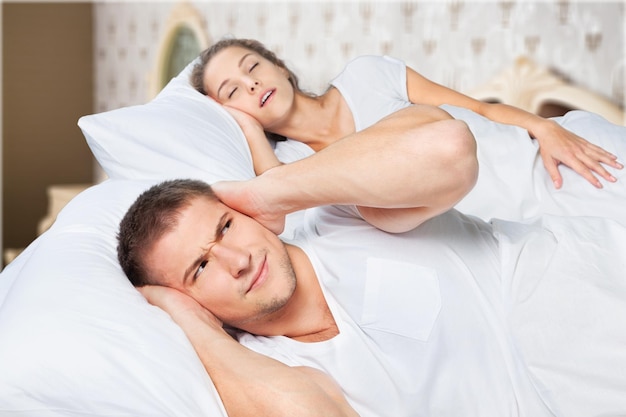 Young  couple sleeping on the bed in bedroom,girl snores