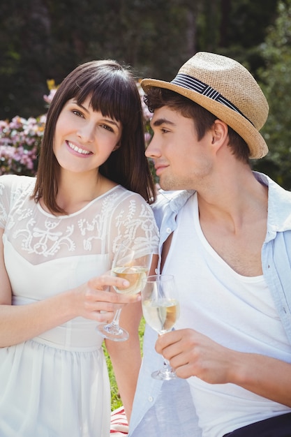 Young couple smiling and having glass of wine in garden