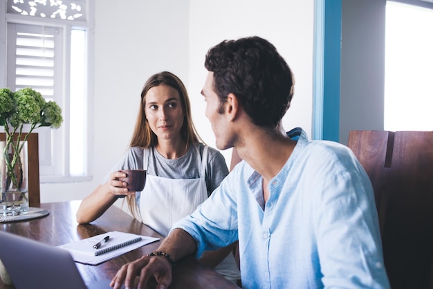 Young couple speaking at home table