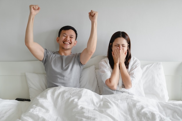 Young couple sport fans cheering team victory while watching football match on tv.