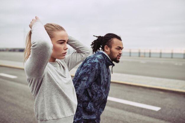 Photo young couple in sportswear preparing for a run together