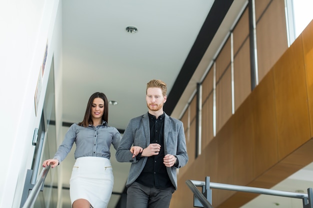 Young couple on the stairs in office