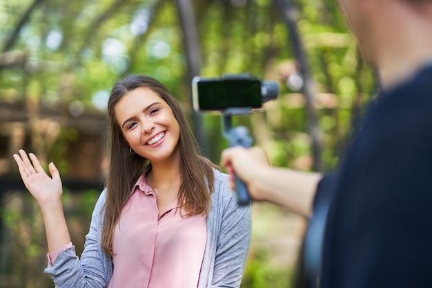 young couple strolling in the park and taking pictures