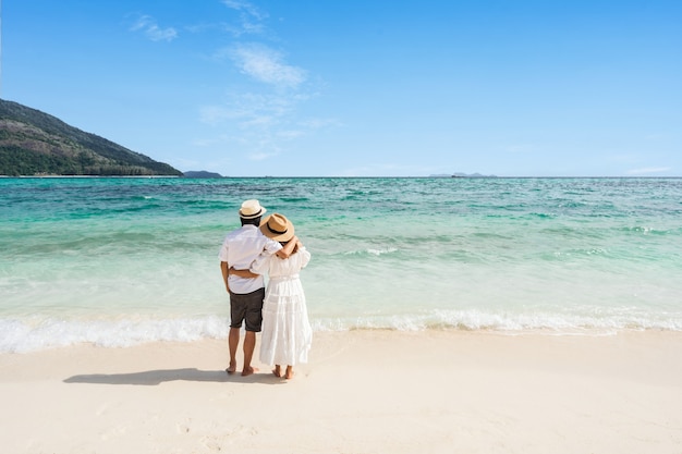 Young couple in summer clothes hugging at the beach