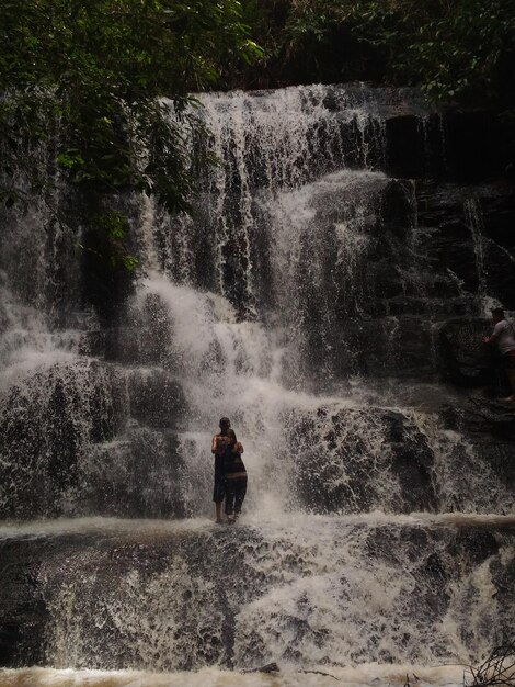 Photo young couple taking selfie by waterfall