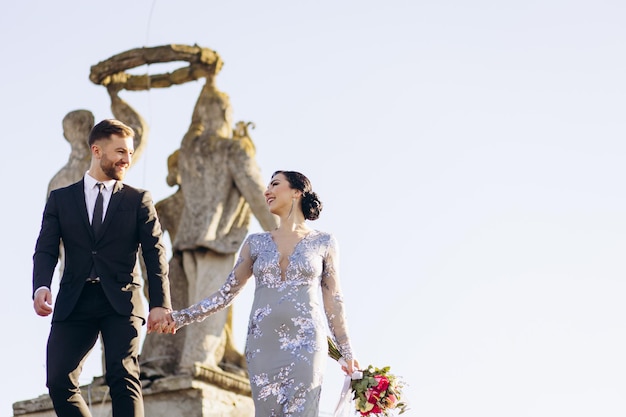 Photo young couple on their wedding anniversary having photoshoot on the roof of the theatre