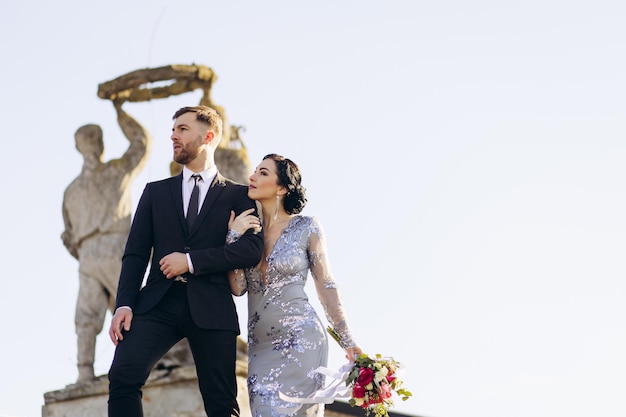 Photo young couple on their wedding anniversary having photoshoot on the roof of the theatre