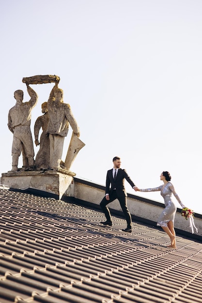 Photo young couple on their wedding anniversary having photoshoot on the roof of the theatre