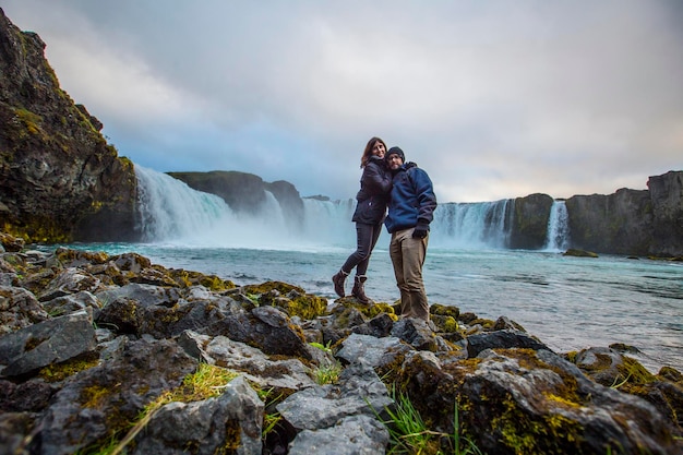 A young couple tourist looking at the Godafoss waterfall from above Iceland