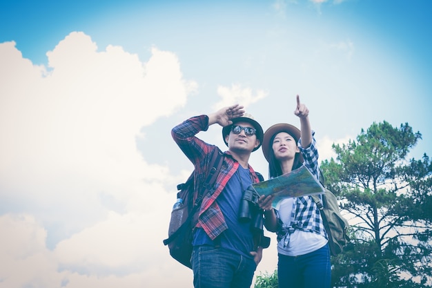 Young couple tourists with map in the park. Adventure.