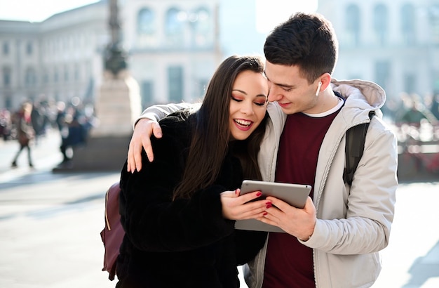 Young couple using a digital tablet outdoor while visiting a city