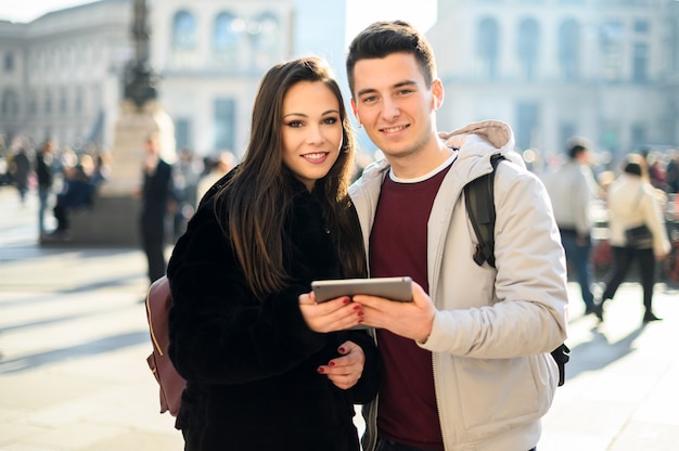 Young couple using a digital tablet outdoor while visiting a city