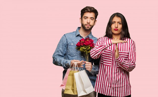 Young couple in valentines day doing a timeout gesture