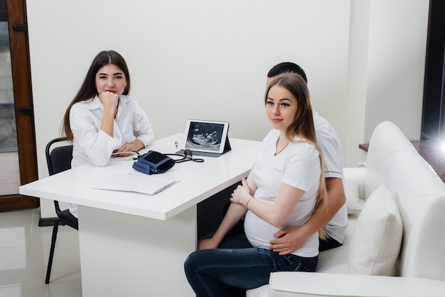 A young couple waiting for a baby to consult a gynecologist after an ultrasound. Pregnancy, and health care