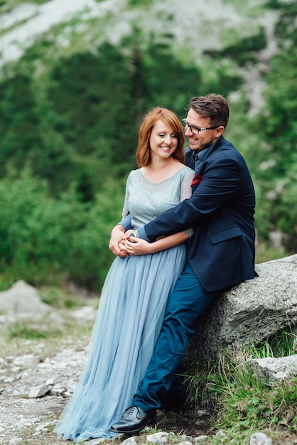 Young couple on a walk near the lake surrounded by the Carpathian mountains