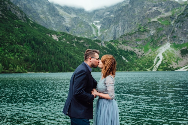 Young couple on a walk near the lake surrounded by the Carpathian mountains