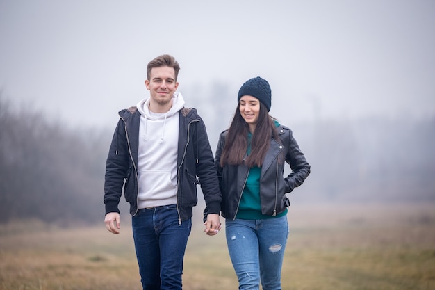 Young couple walking in nature on a foggy winter day