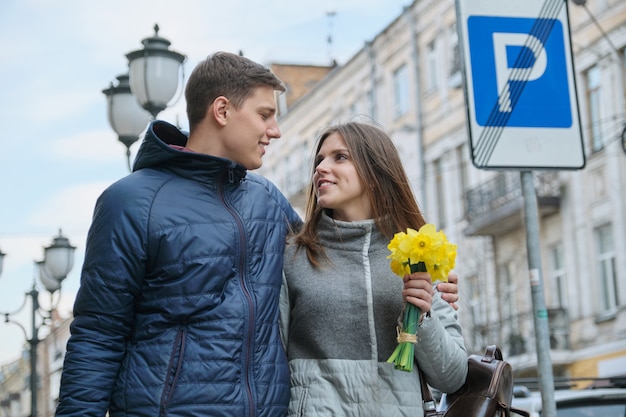 Young couple walking with bouquet of yellow spring flowers