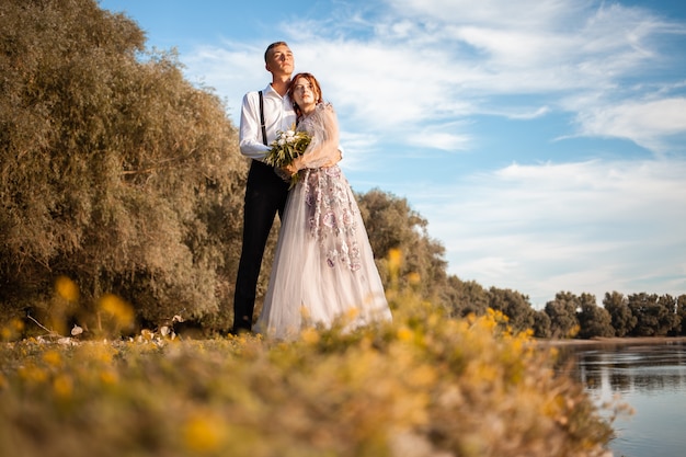 young couple on the wedding day by the lake