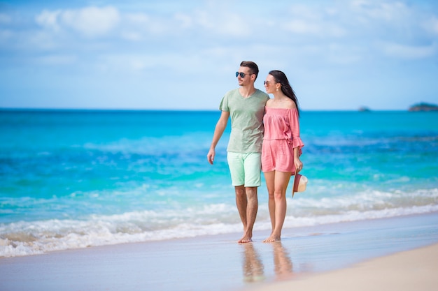 Young couple on white beach. Happy family on honeymoon vacation