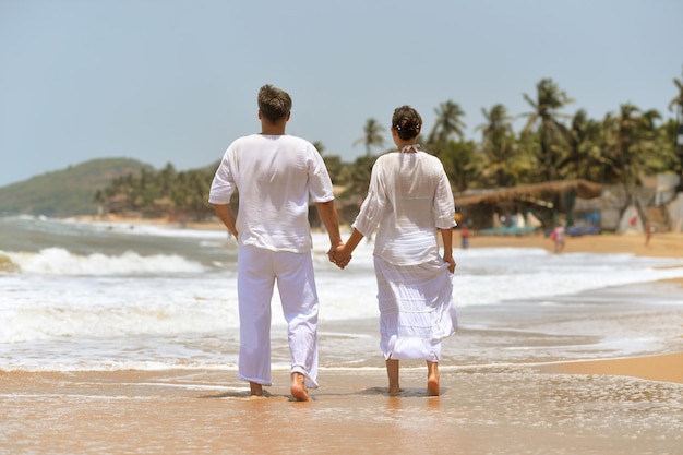 Young couple in white clothing walking