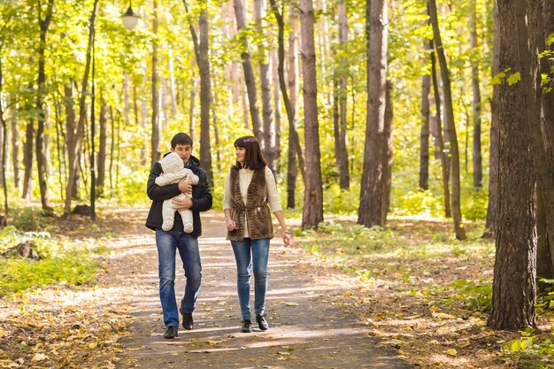 Young couple with newborn son outdoors in autumn