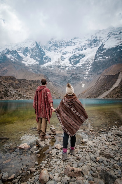 A young couple with ponchos on vacation in Laguna Humantay Peru