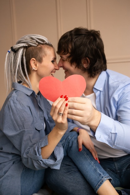 Young couple with red heart valentine in hands.