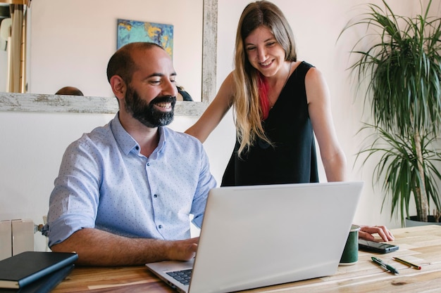 young couple working from their living room in their business Looking at things on the laptop