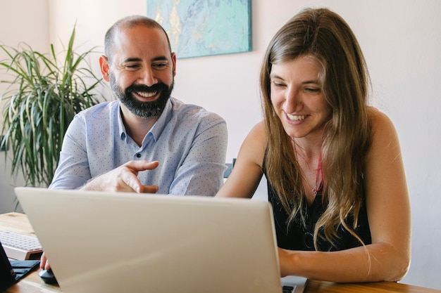 young couple working from their living room in their business Looking at things on the laptop