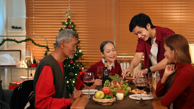 Young coupler celebrating Christmas or New Year with grandparents at cozy home Holidays and celebration concept