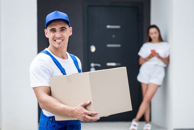 Young courier delivering goods to a young woman at home